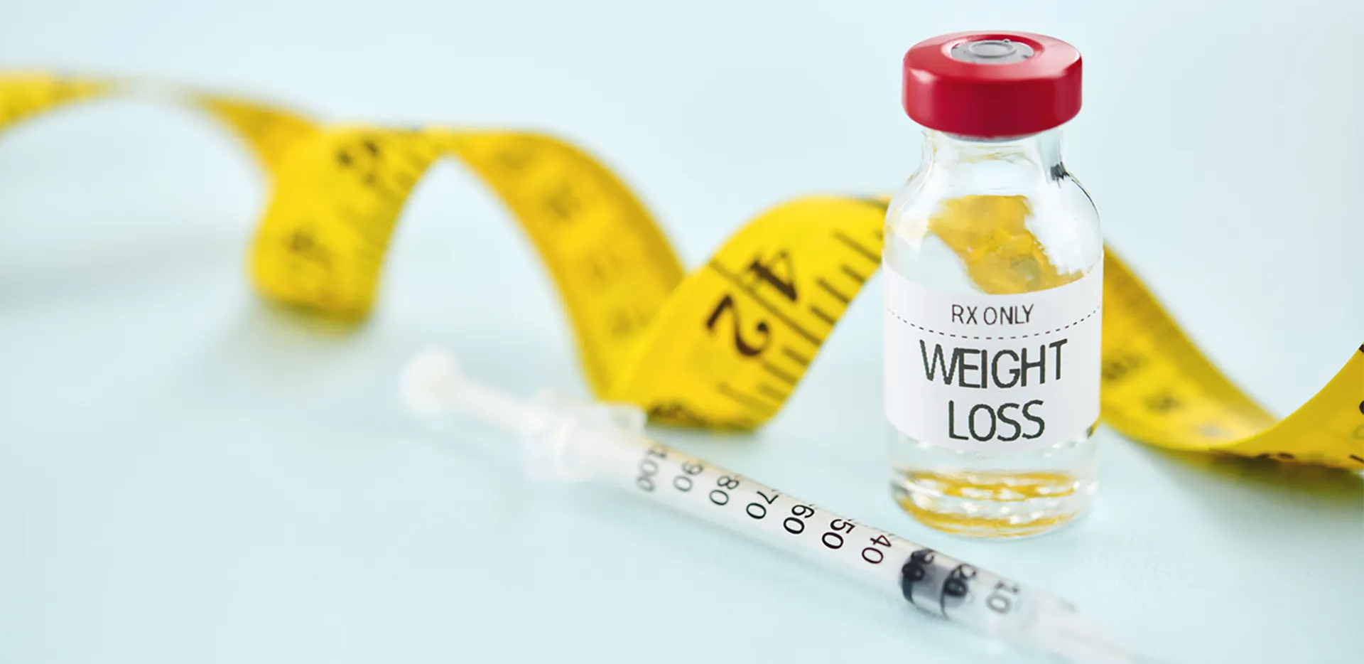 A syringe and medicine bottle labeled weight loss.