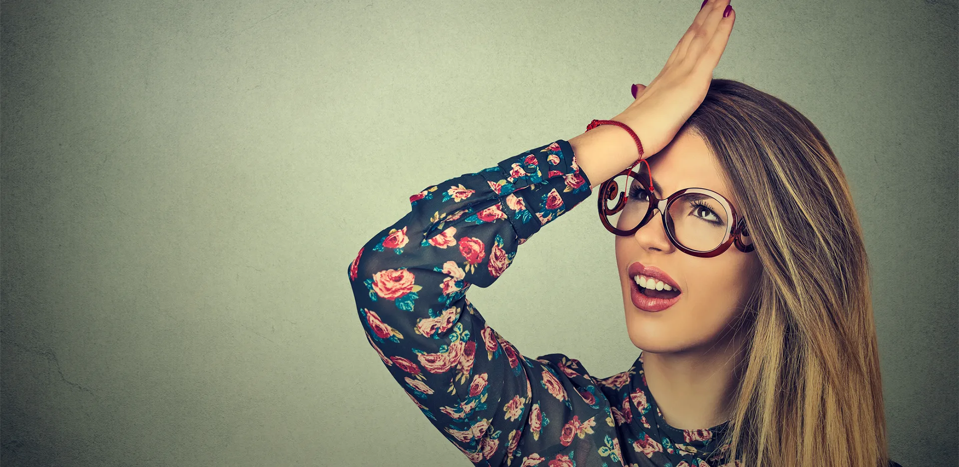 A woman pressing her palm to her forehead in frustration.
