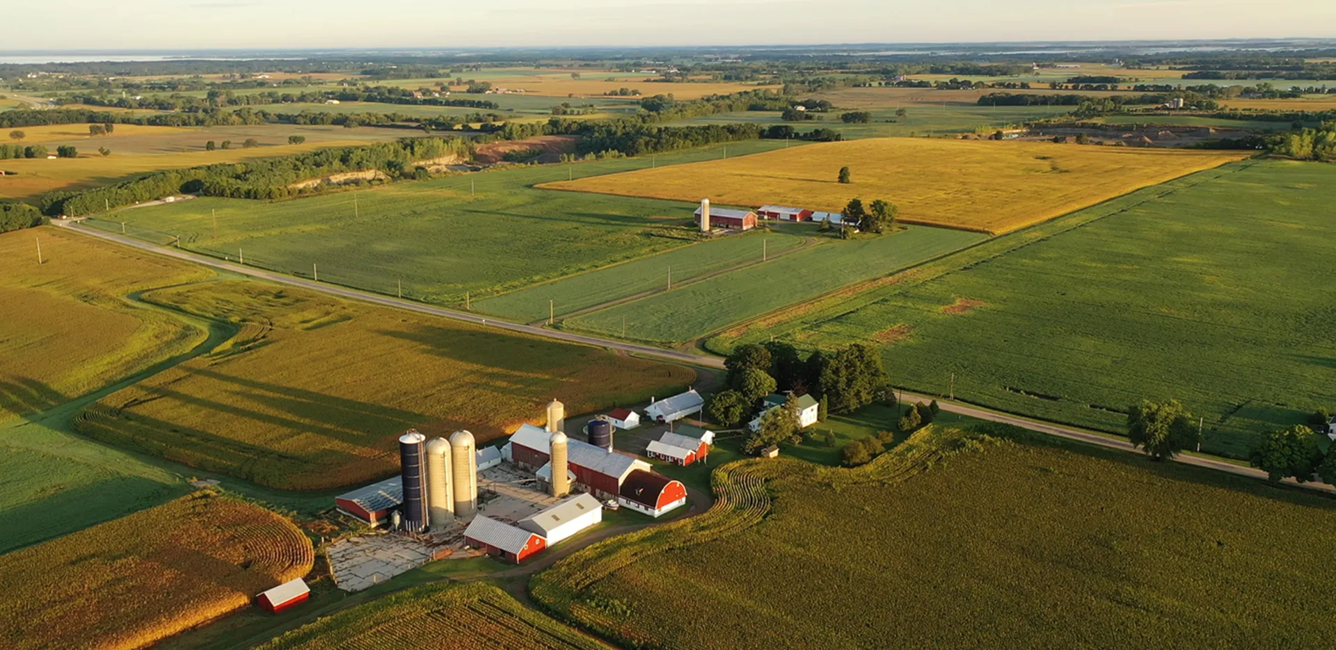 An aerial image of a farm fields, barns and silos.