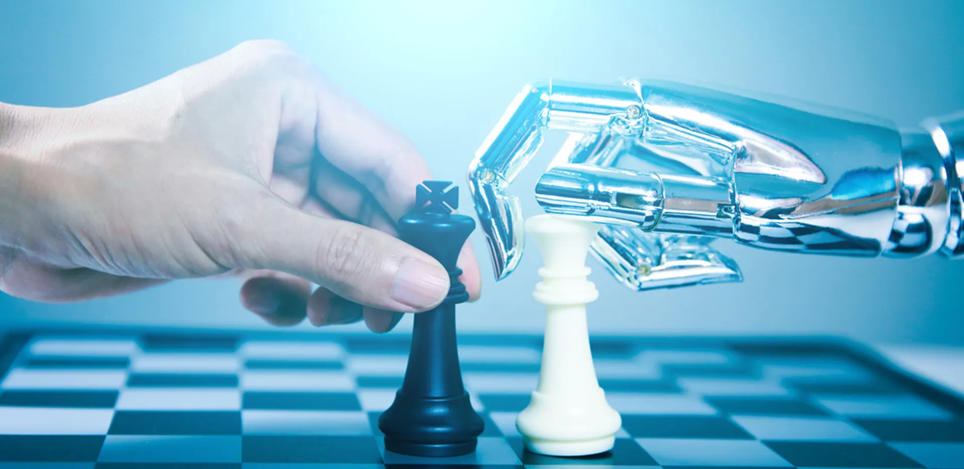 A human hand and a robot hand each grabbing a chess piece on a chess board.
