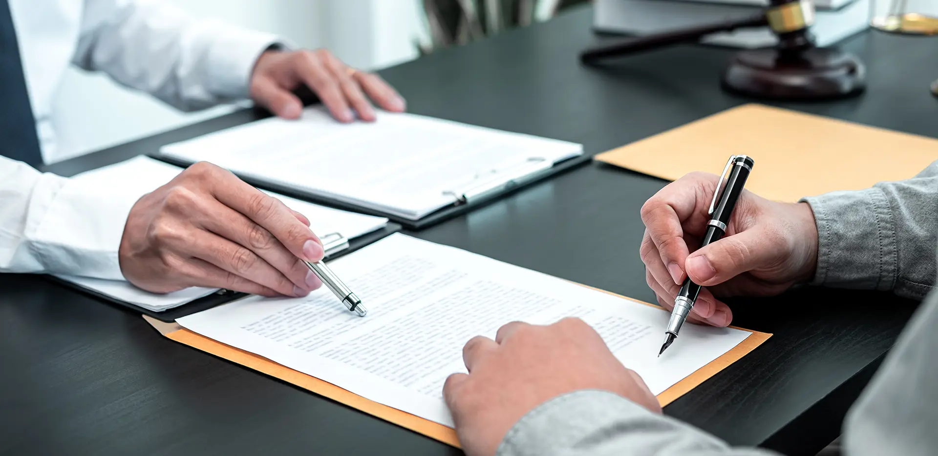 Two people looking over paperwork on a desk.