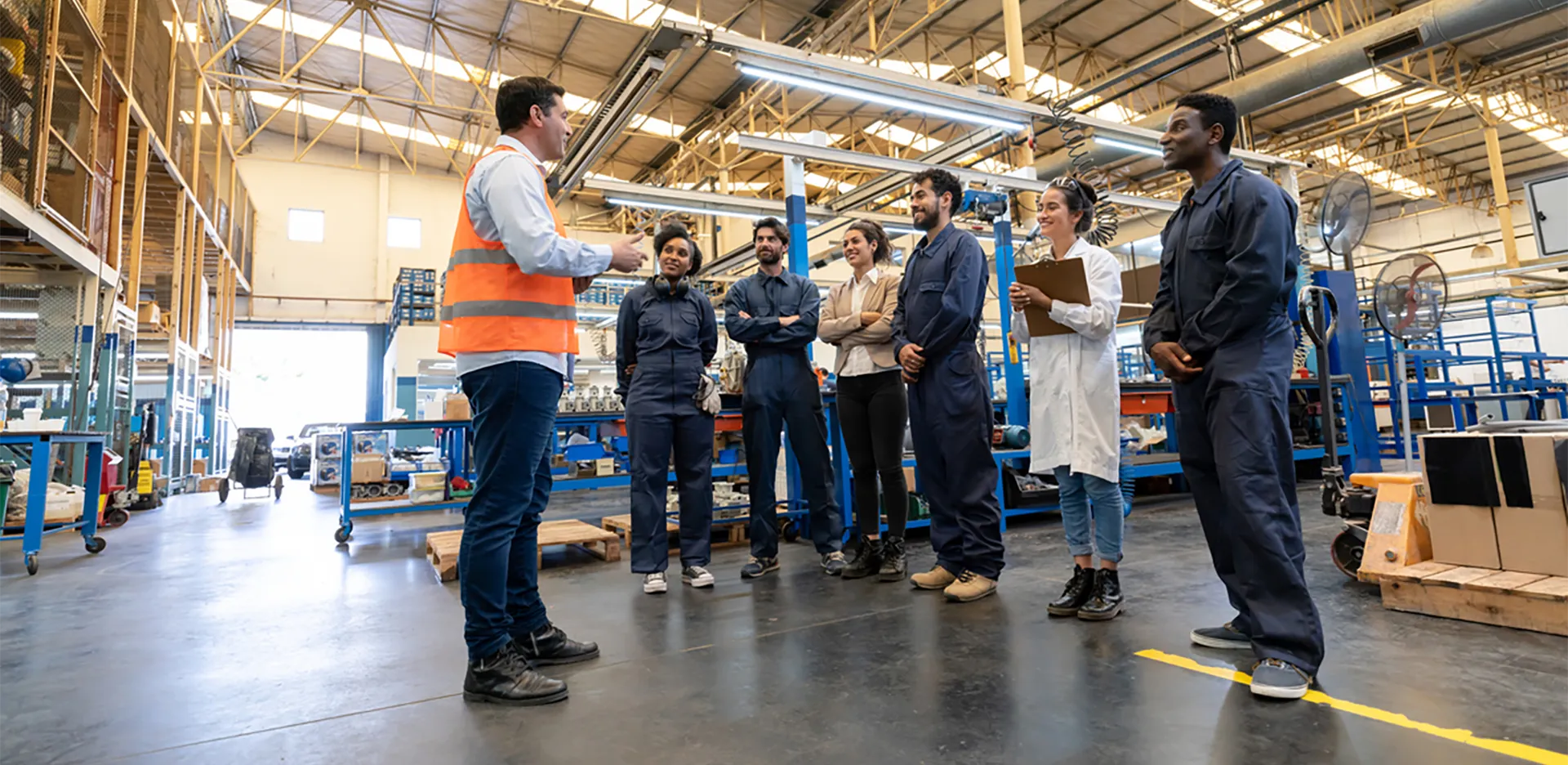 A group of workers in an industrial setting in a meeting.