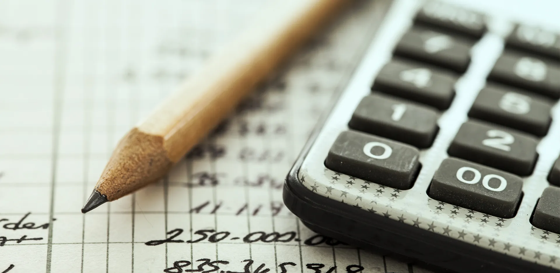 Close-up of a calculator and a pencil.