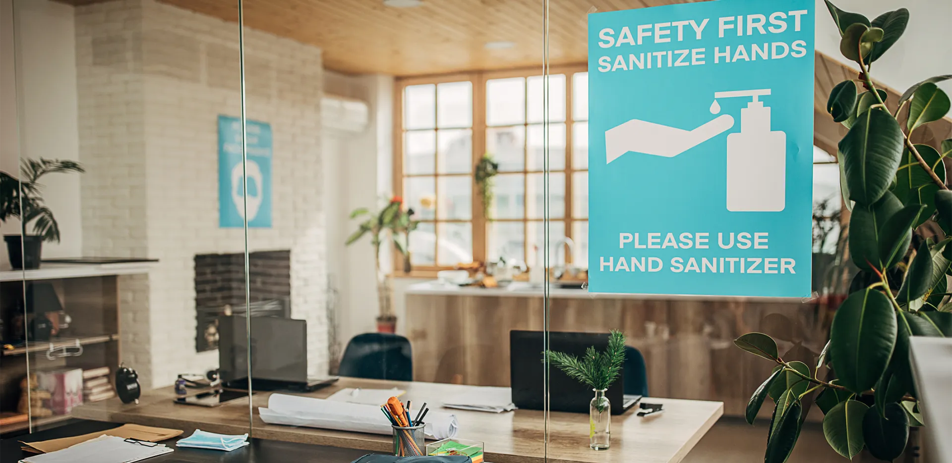 A glass door in an office with a sign promoting hand sanitizer.