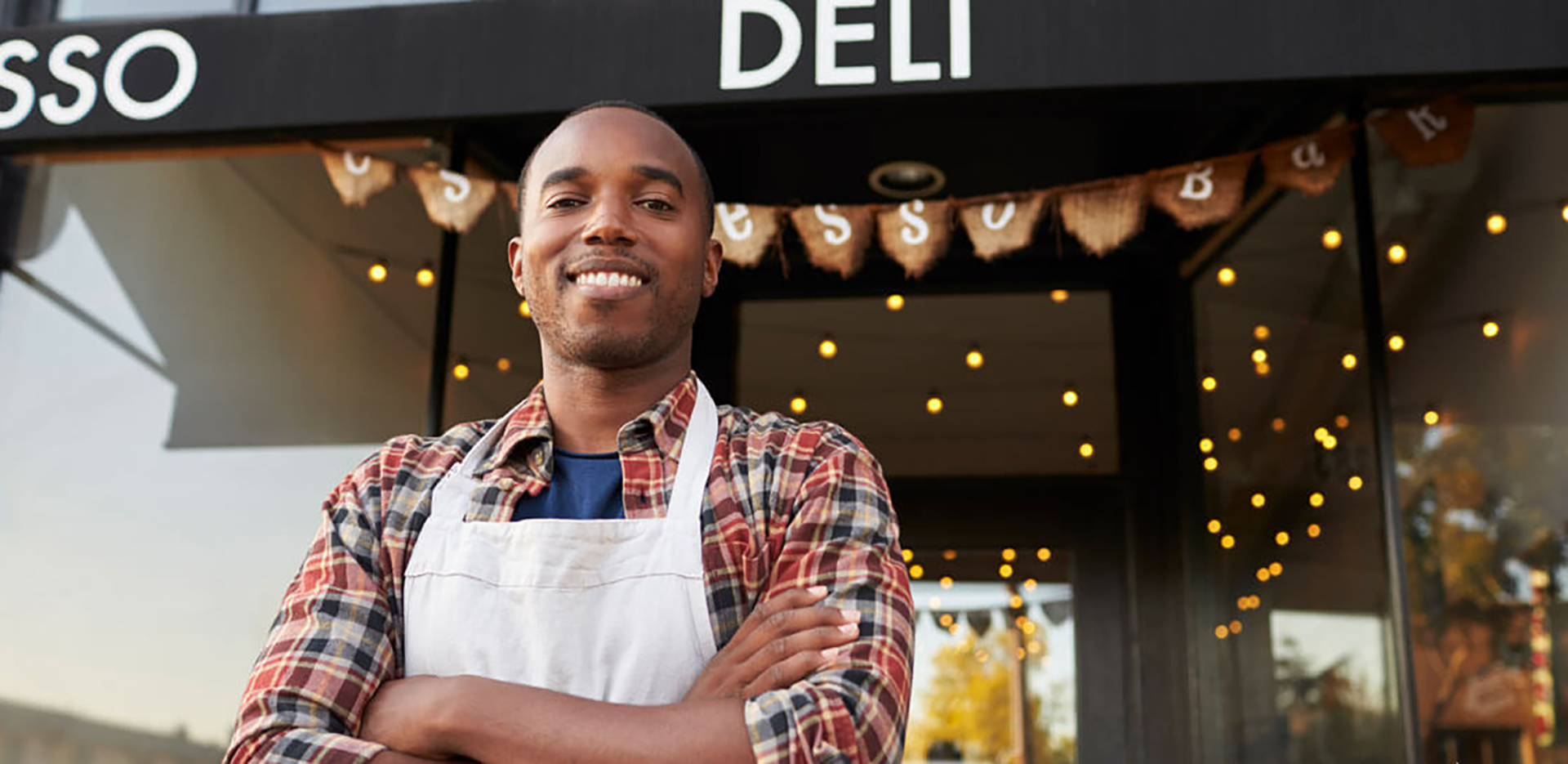 A business owner standing in front of his Deli business.