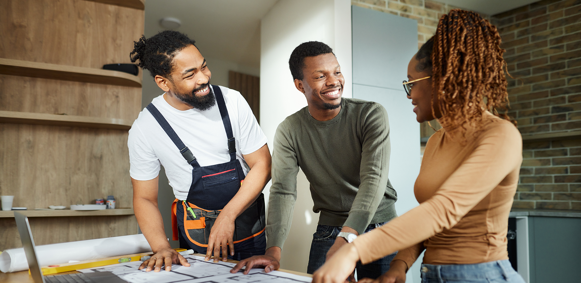 A contractor reviewing blueprints with his customers.