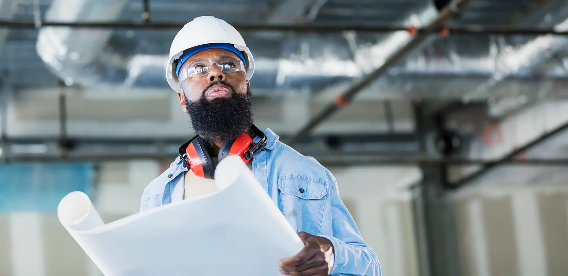 A contractor reviewing a set of blueprints.