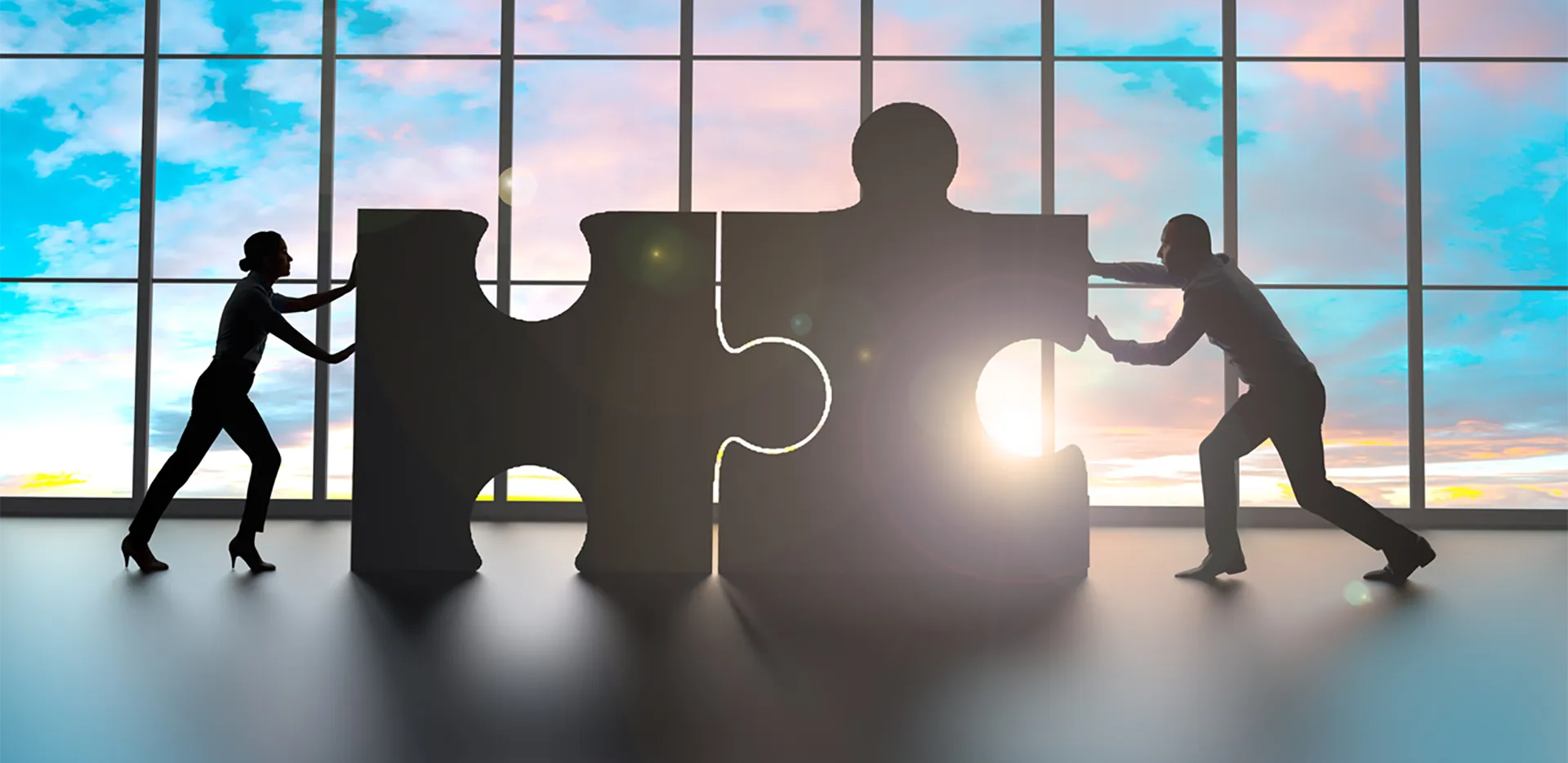 Two professionals pushing enormous puzzle pieces together.