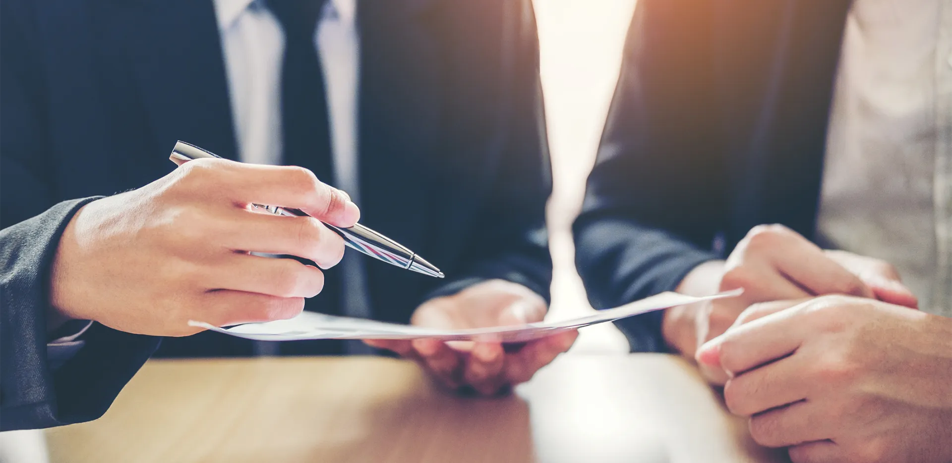 People wearing suits filling out paperwork.