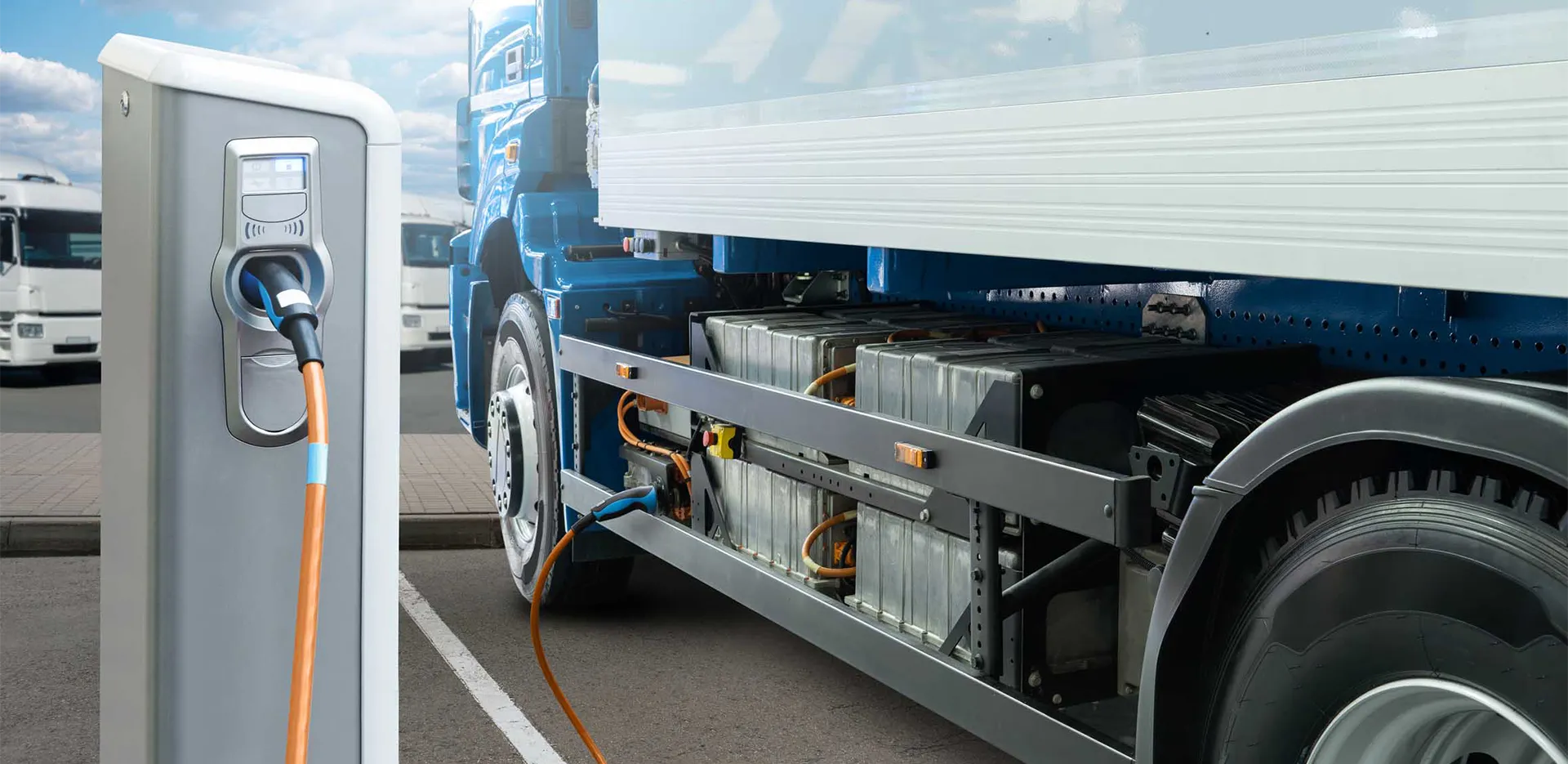 An electric big rig vehicle plugged into a charging station.