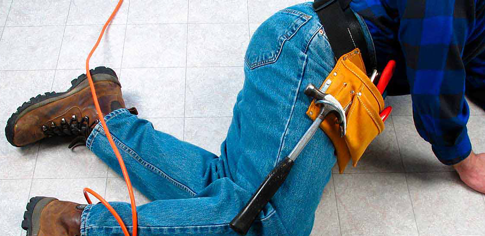A person wearing jeans and a toolbelt has fallen.