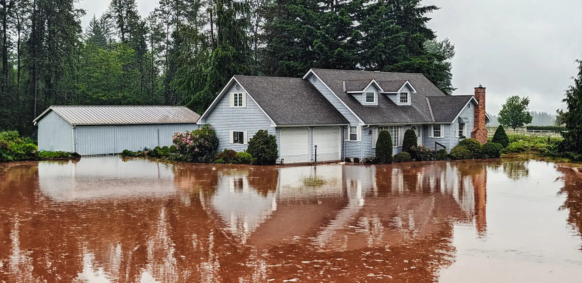 A home surrounded by flood waters on a rainy day.