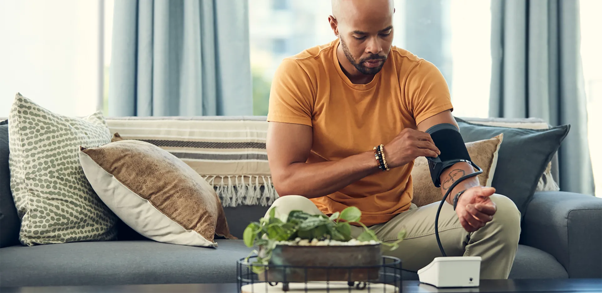 A man taking his blood pressure at home with a blood pressure cuff.