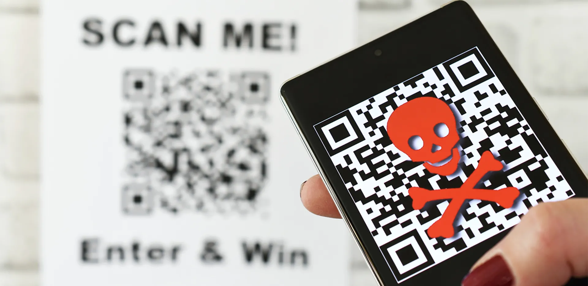 Someone scanning a QR code with their phone. The phone shows a skull and crossbones.