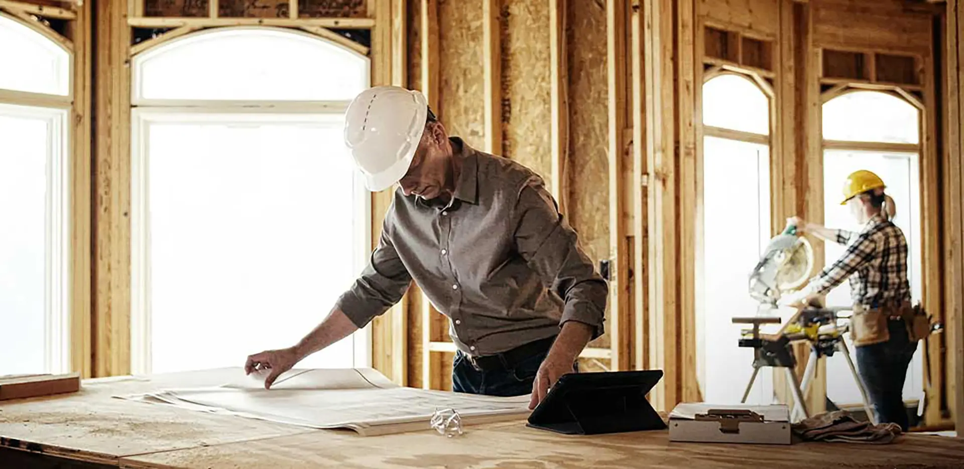 A construction worker reviewing blueprints.