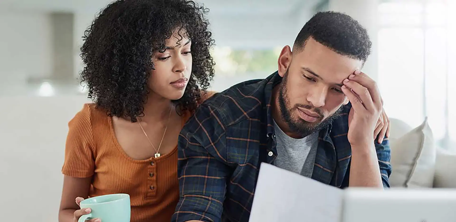 A couple reviewing insurance documents looking stressed.