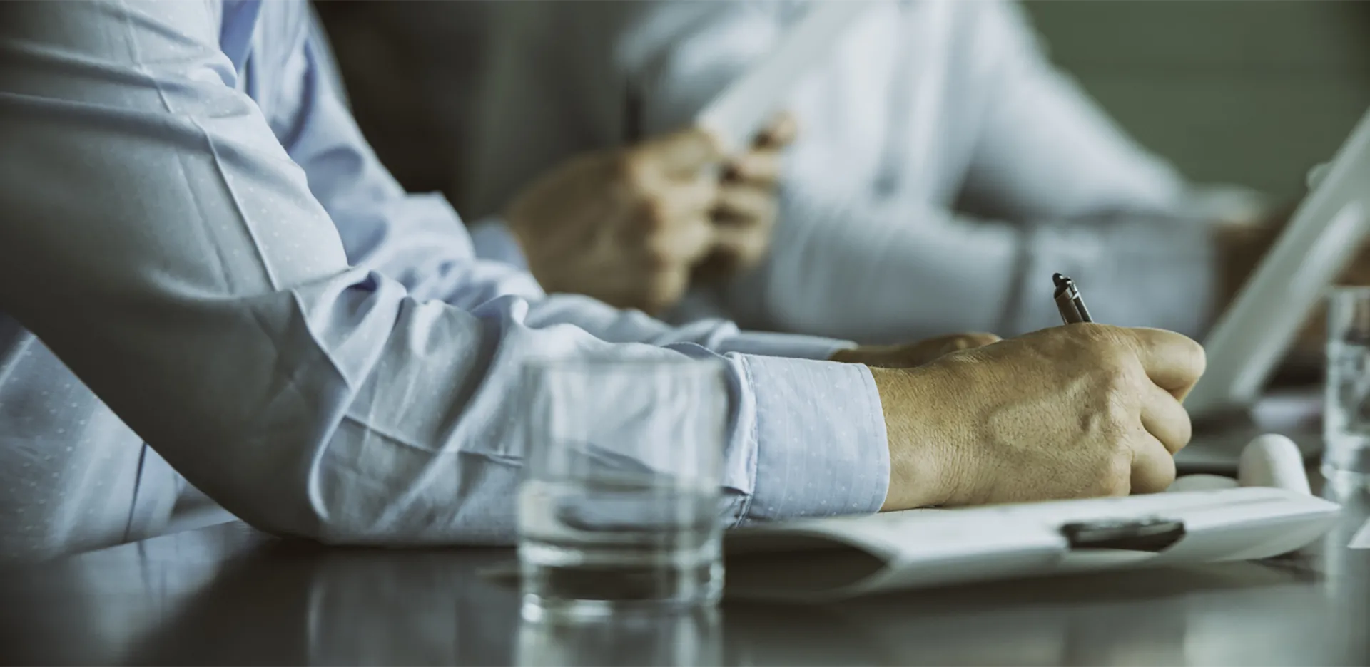 A professional wearing a button up shirt taking notes.