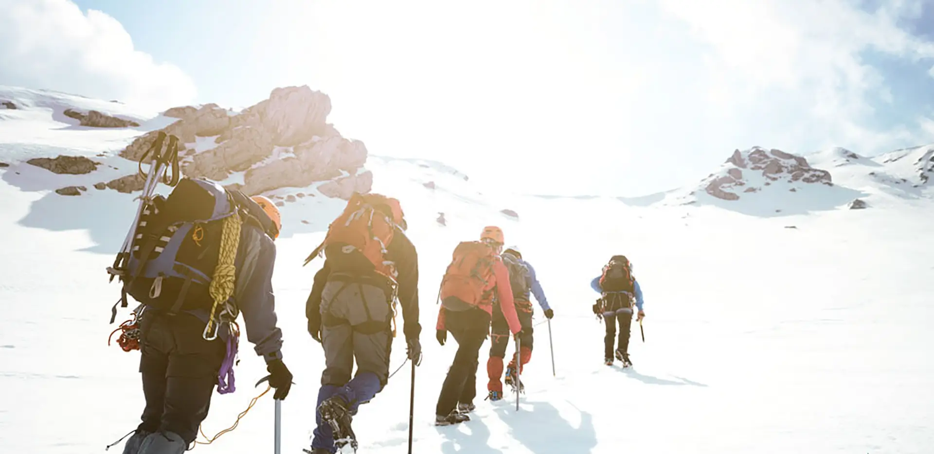 A group of snowshoers climbing a mountain.