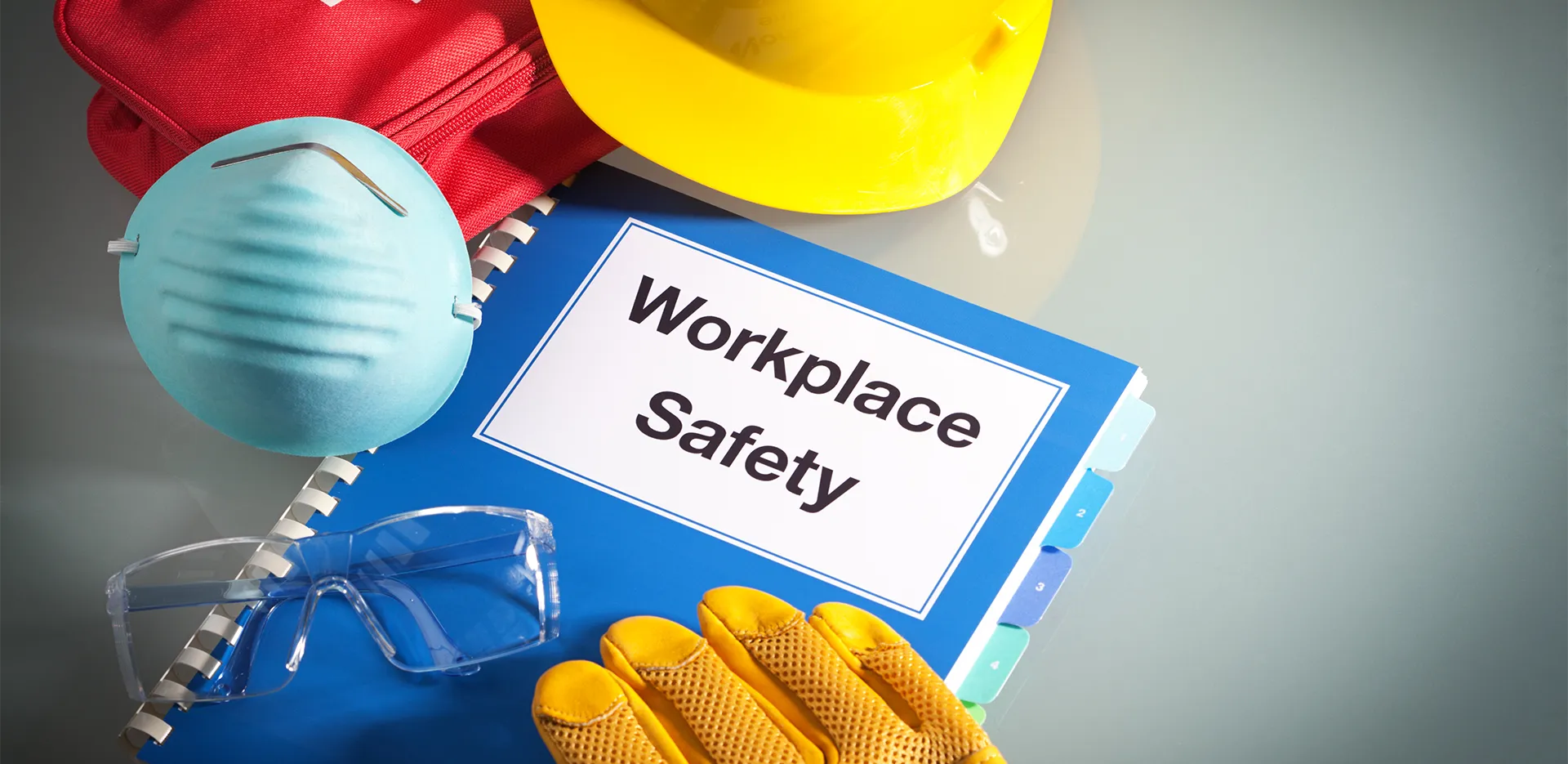 A booklet surrounded by equipment. The booklet reads 'Workplace Safety.'