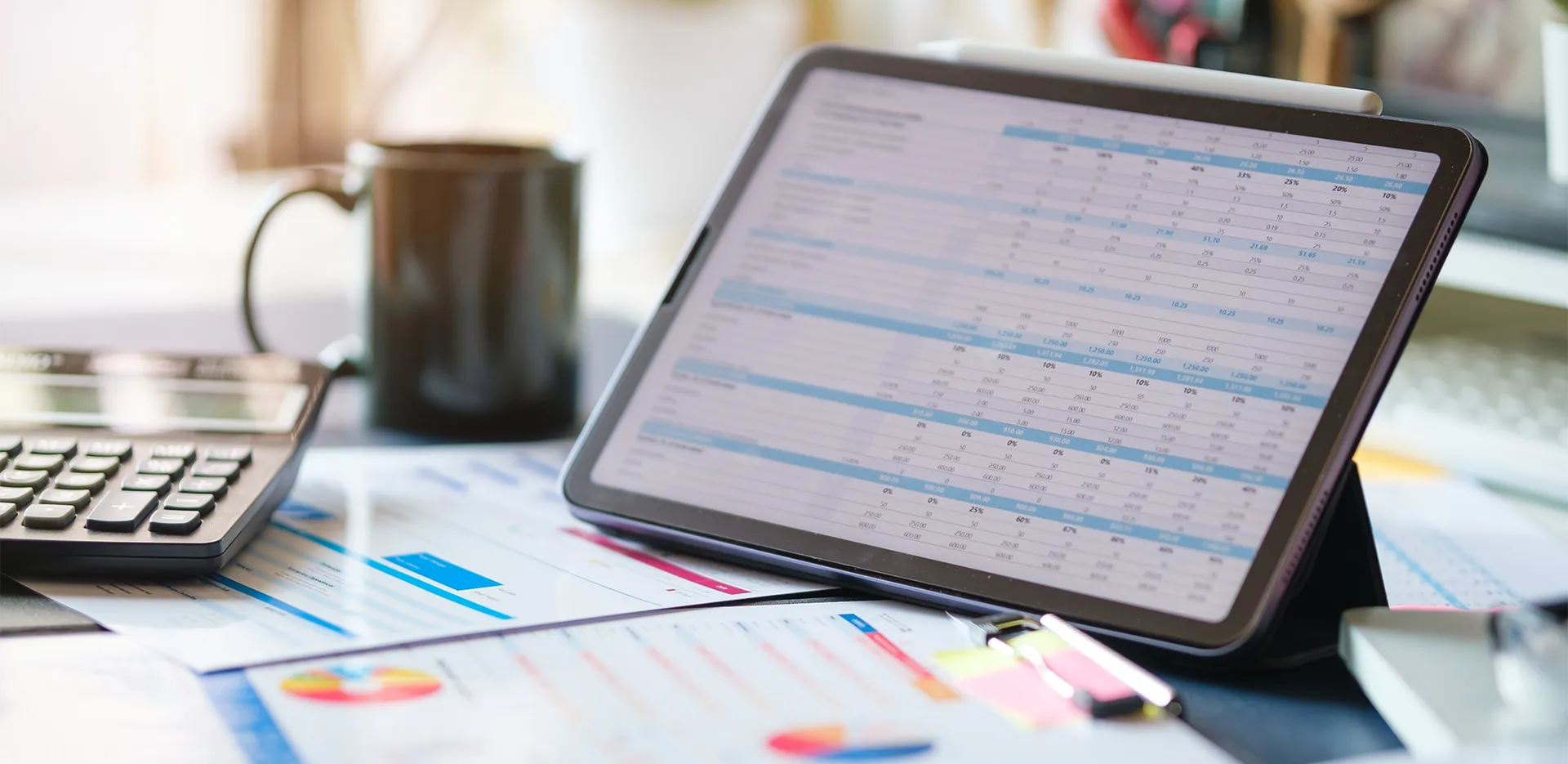 A tablet computer showing a spreadsheet propped up on a desk.