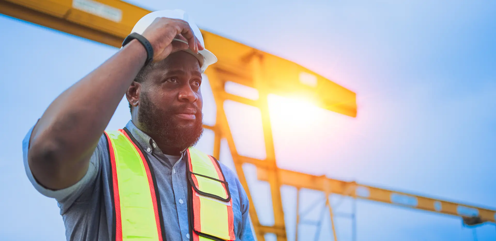 A construction worker adjusting his hard hat.