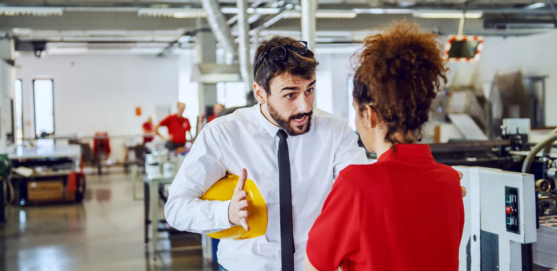 Two professionals arguing in a factory environment.