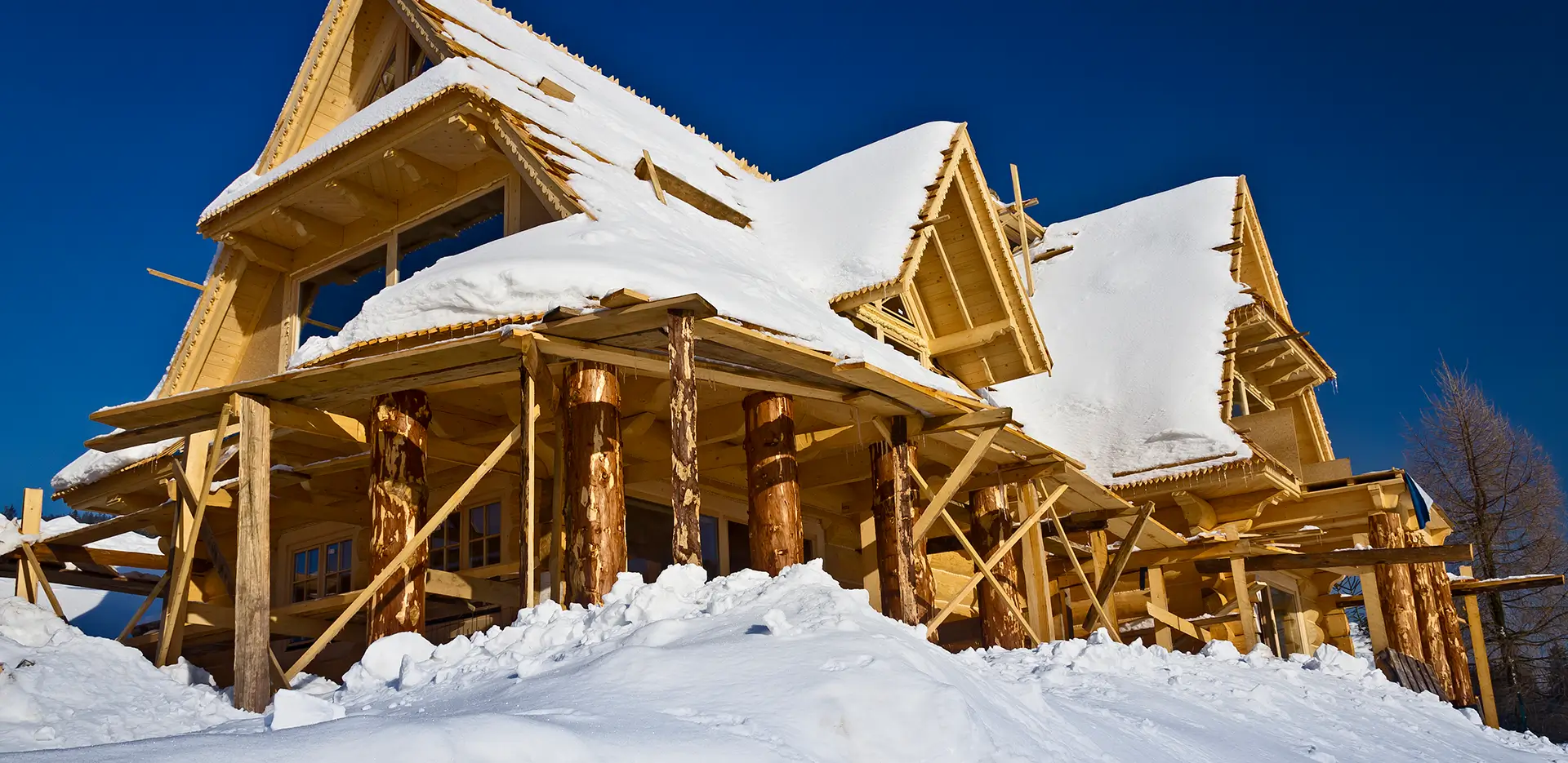 A home made of wood covered in snow.