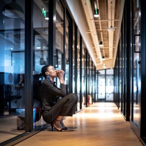 Worried young business woman at corridor office