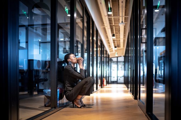 Worried young business woman at corridor office